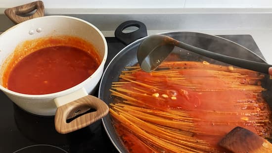 Los spaghetti se van cociendo en ese caldo de salsa de tomate - La mesa del Conde